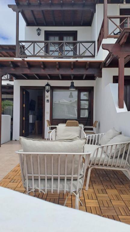 a patio with a table and chairs on a deck at Iris 25 in Playa Blanca