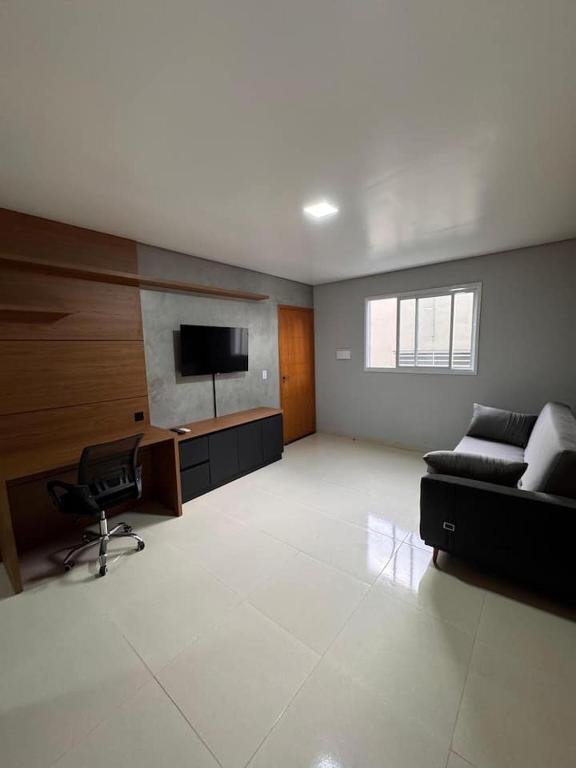 a large living room with a couch and a television at Uruguaiana House in Uruguaiana