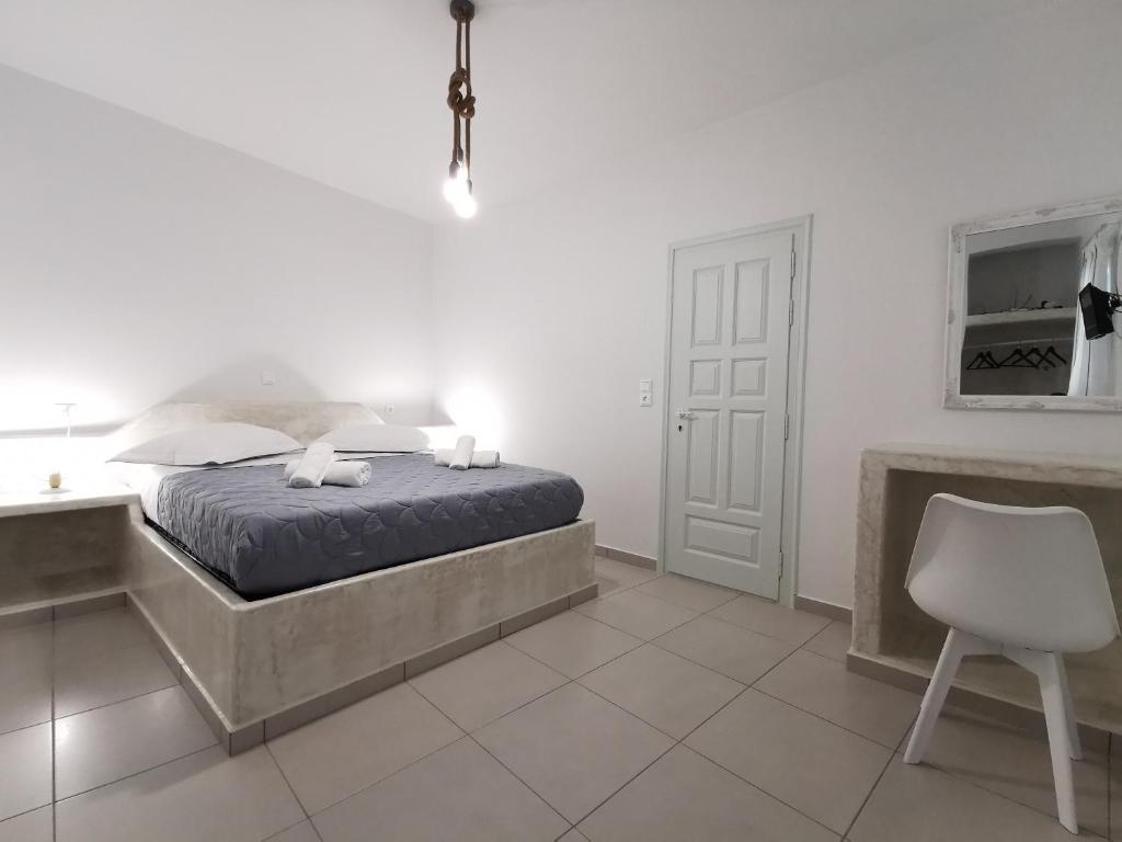 a bedroom with a bed and a desk and a chair at Meltemi Chora Amorgos in Amorgos