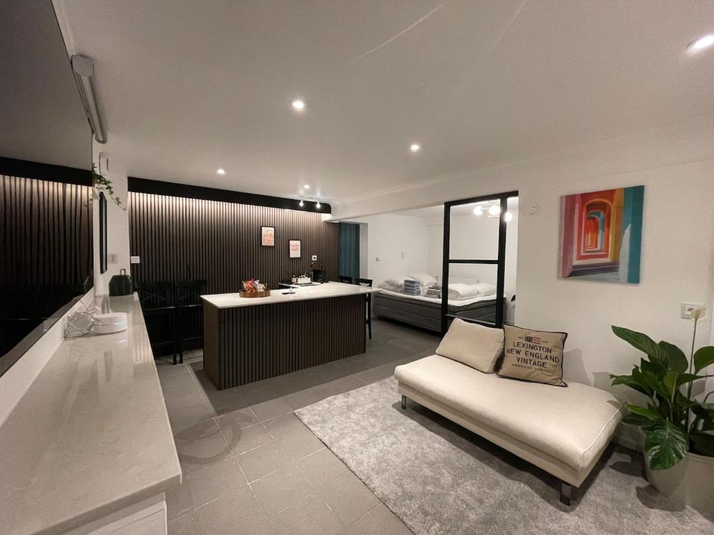 a living room with a couch and a kitchen at Sydney Homestay in Mölndal