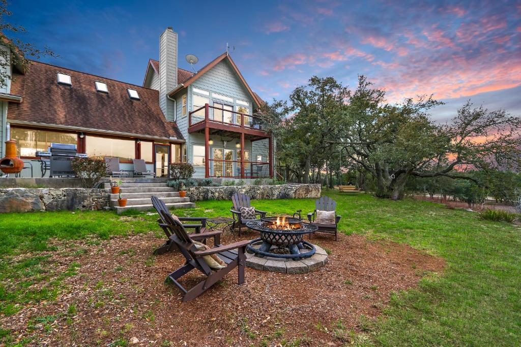 a backyard with a fire pit in front of a house at Casa Robles- The Bluebonnet in Wimberley
