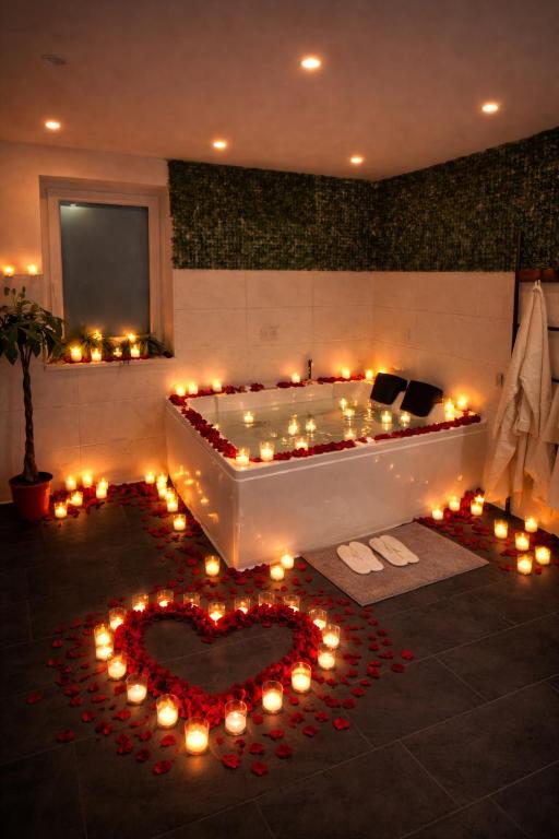 a bathroom with a tub with a heart made out of candles at Wood Spa Wellness Suite mit Whirlpool & Sauna nahe Göttingen in Rosdorf
