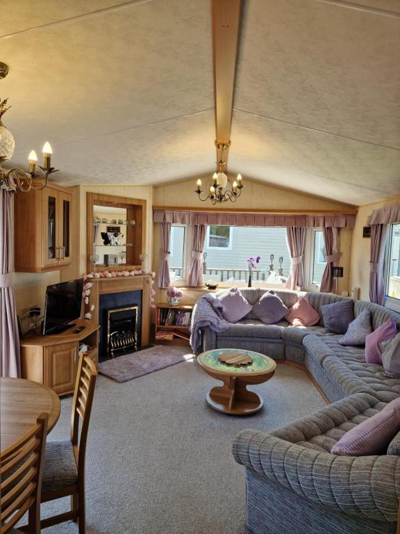 a living room with a couch and a table at BELLESVIEW Clarach Bay in Aberystwyth