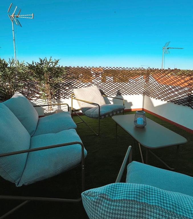 a patio with chairs and tables on a roof at Refúgio da Azinheira in Torrão