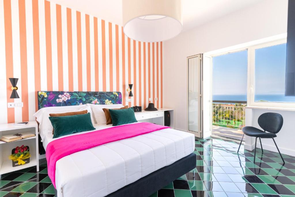 a bedroom with a bed and a balcony with the ocean at Vanity Suite in Sorrento