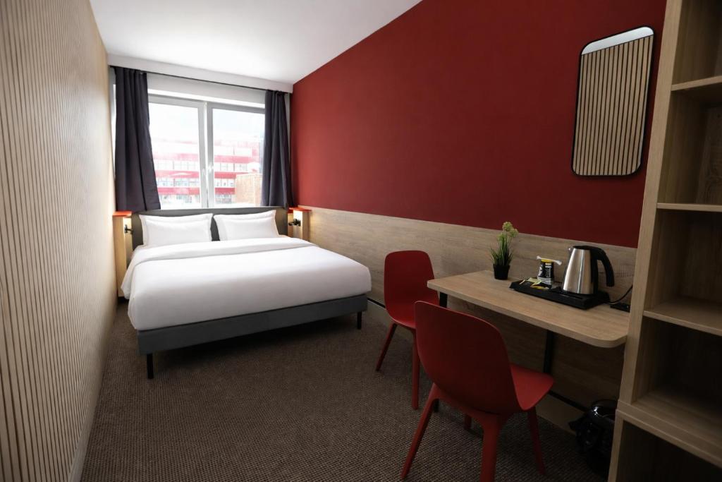 a hotel room with a bed and a table and chairs at NIVAN Hostel in Hamburg
