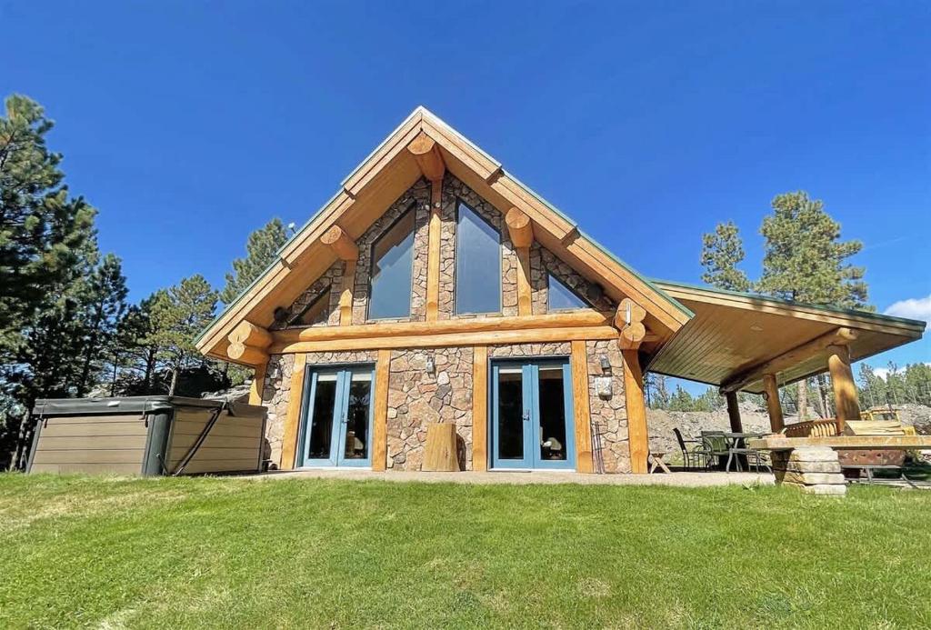 a log cabin with a picnic table in the grass at Granite Ridge Cabin in Keystone