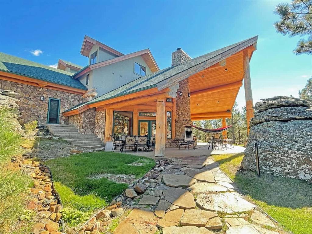 a large stone house with a large deck and a patio at Granite Ridge Lodge in Keystone