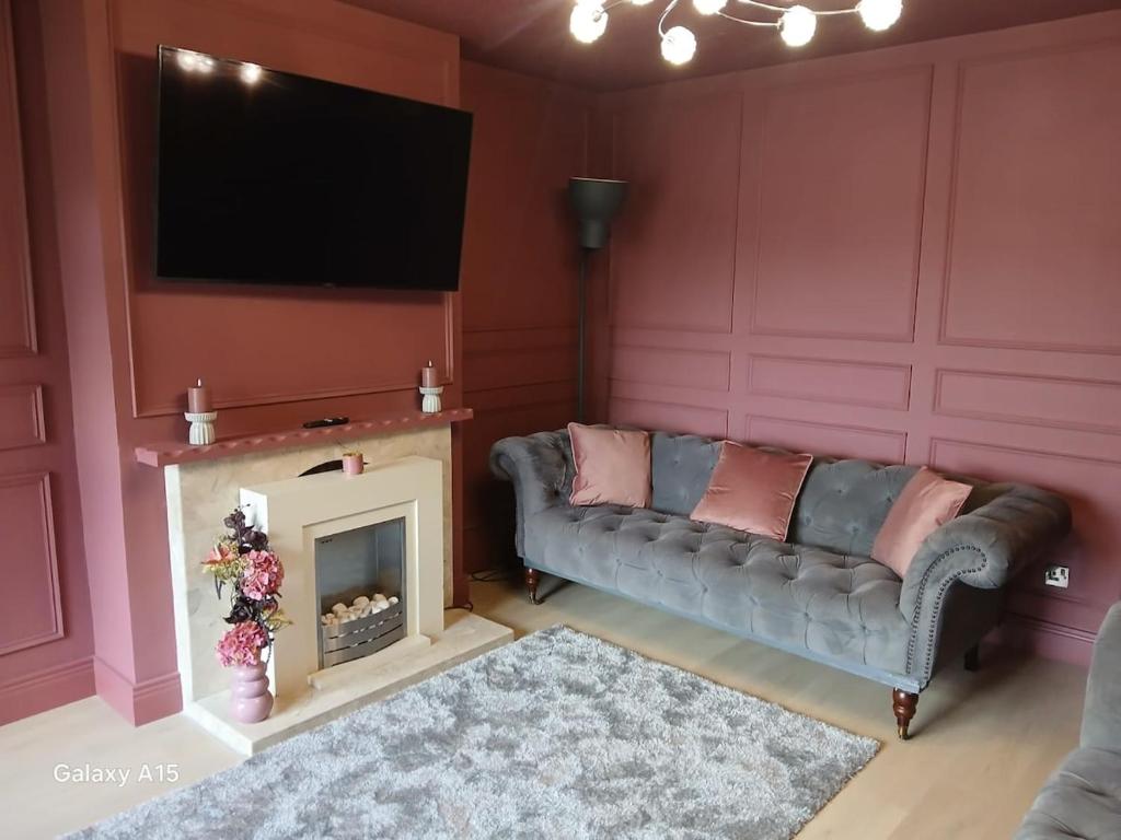 a living room with a couch and a fireplace at The Greenway Getaway in Abbeyside