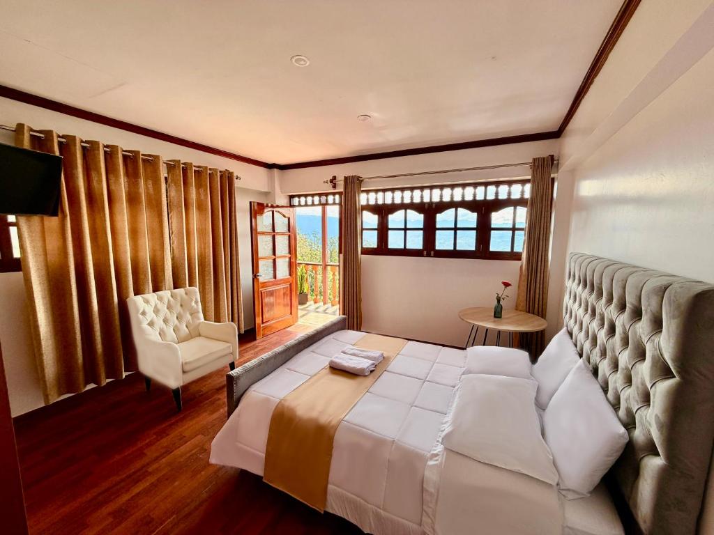 a bedroom with a bed and a chair and a window at Andina Amazon Lodge in Chachapoyas