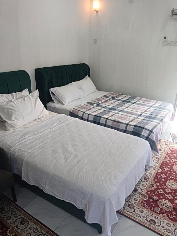two beds sitting next to each other in a room at Tiny House Anjung Batu Tangkak in Tangkak