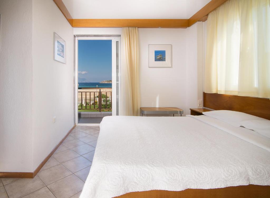 a bedroom with a bed and a view of the ocean at Linaraki Studios & Apartments in Sykia Chalkidikis