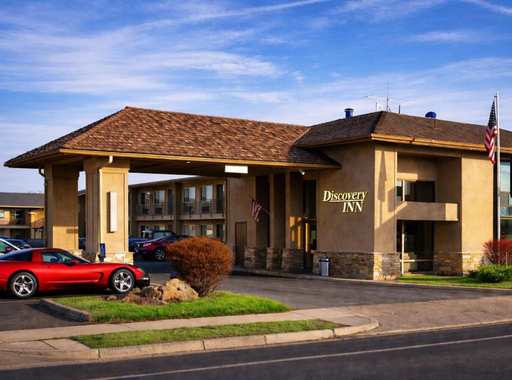 a building with a red car parked in front of it at Discovery Inn in Midvale