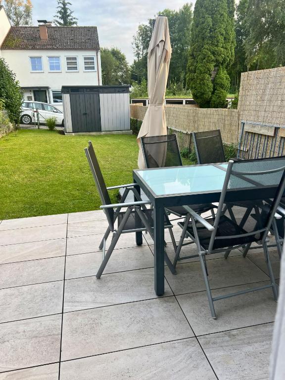 a table and two chairs and an umbrella on a patio at Modernes Reihenhaus mit Terrasse drei Schlafzimmer fuer sechs Personen in Kempten