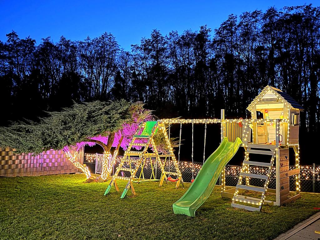 a playground with a slide in a yard at night at Familienfreundliche Ferienwohnung mit Garten & Spielplatz nahe Nürnberg Playmobil FunPark in Veitsbronn