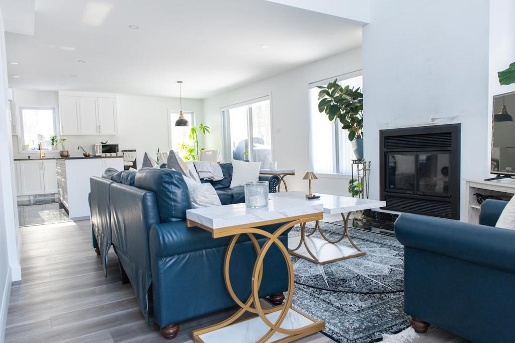 a living room with a blue couch and a table at Cozy Cottage, The Getaway in Quebec in Brownsburg