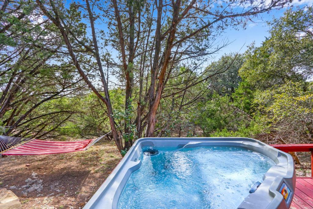 a hot tub in the woods with trees in the background at Cozy Cabin in Wimberley