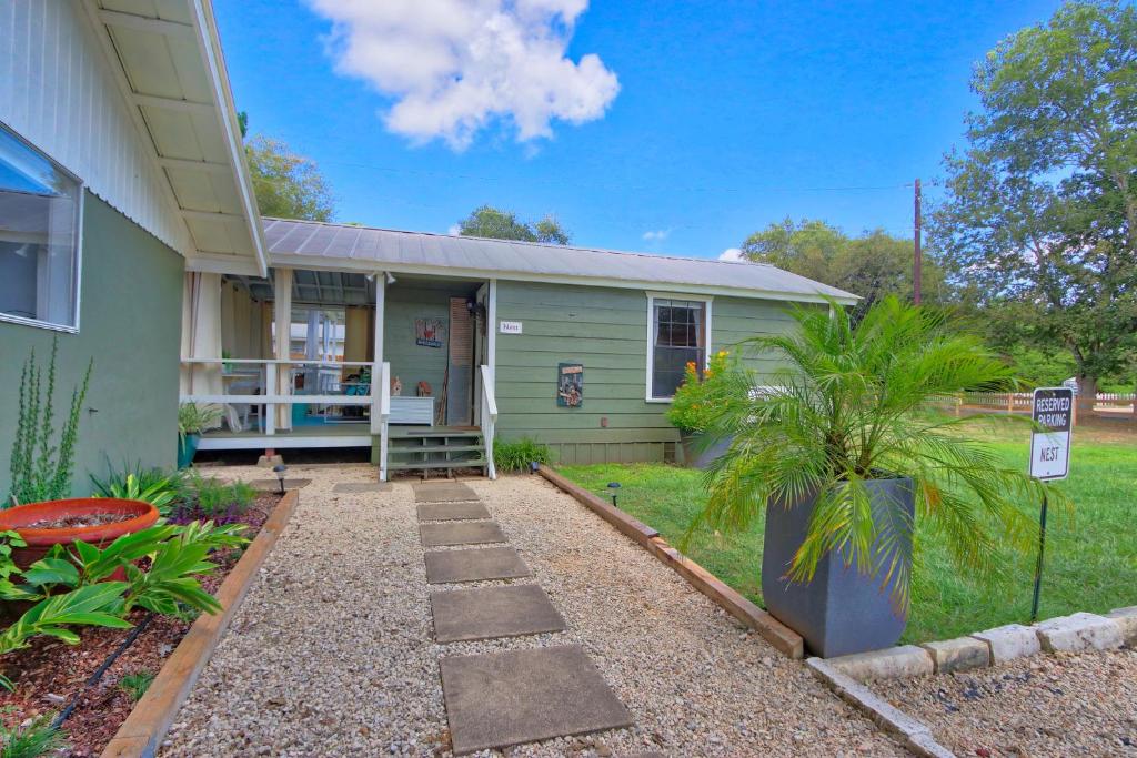 a green house with a pathway in front of it at Creekside Cabins - The Nest in Wimberley