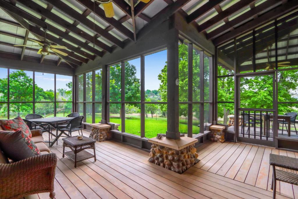 a screened in porch with a fireplace and a table and chairs at River Nest in Wimberley