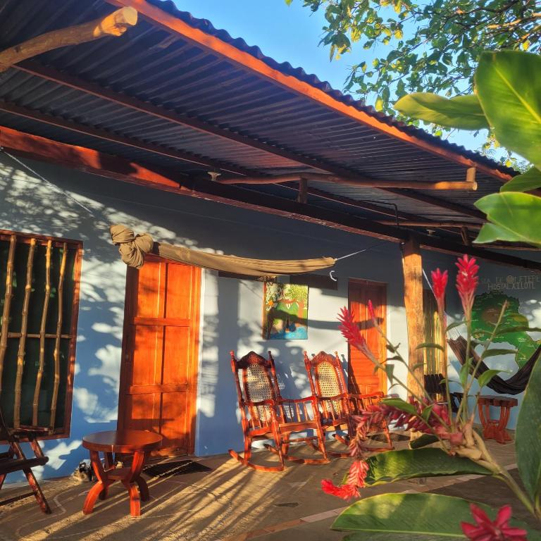 a house with two chairs and a porch at Hostal Xilotl in San José del Sur