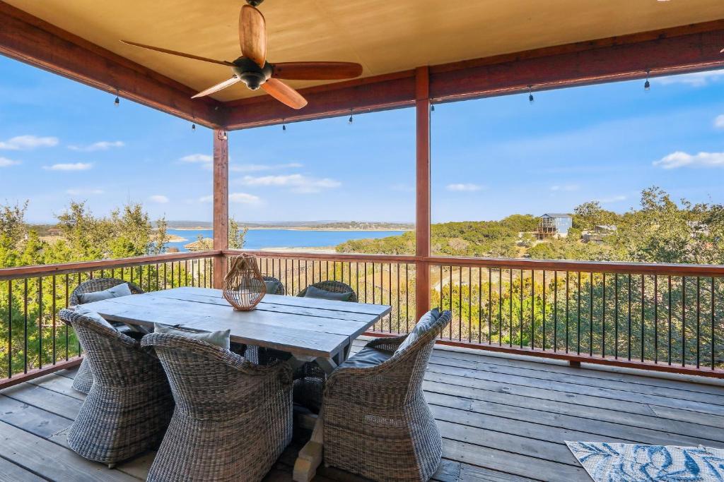 a table and chairs on a deck with a ceiling fan at Riviera Lake House in Canyon Lake