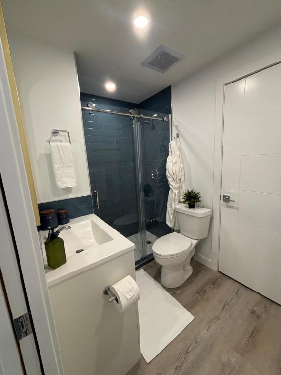 a bathroom with a toilet and a sink and a shower at Hidden Gem in Airdrie