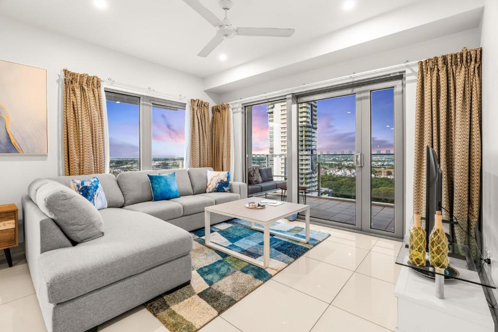 a living room with a couch and a large window at Reef-side Splendour City Vistas - Pool - Workspace in Darwin