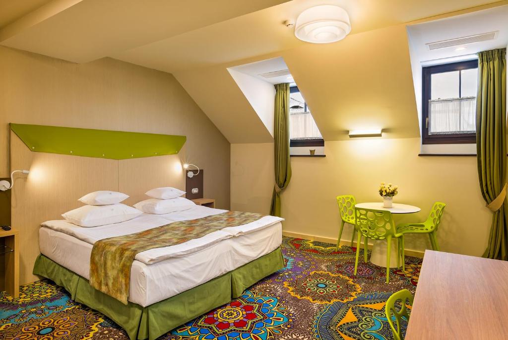 una camera d'albergo con letto e tavolo di Blumenhaus Sibiu a Sibiu