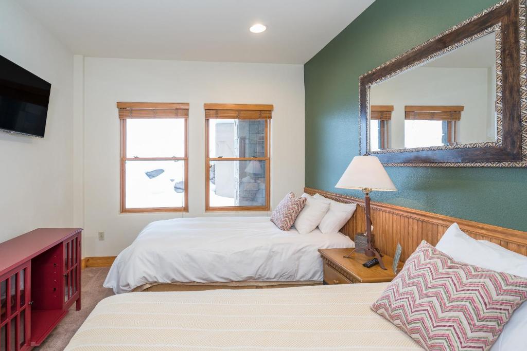 a bedroom with two beds and a mirror on the wall at Bear Creek Lodge 203C Hotel Room in Telluride