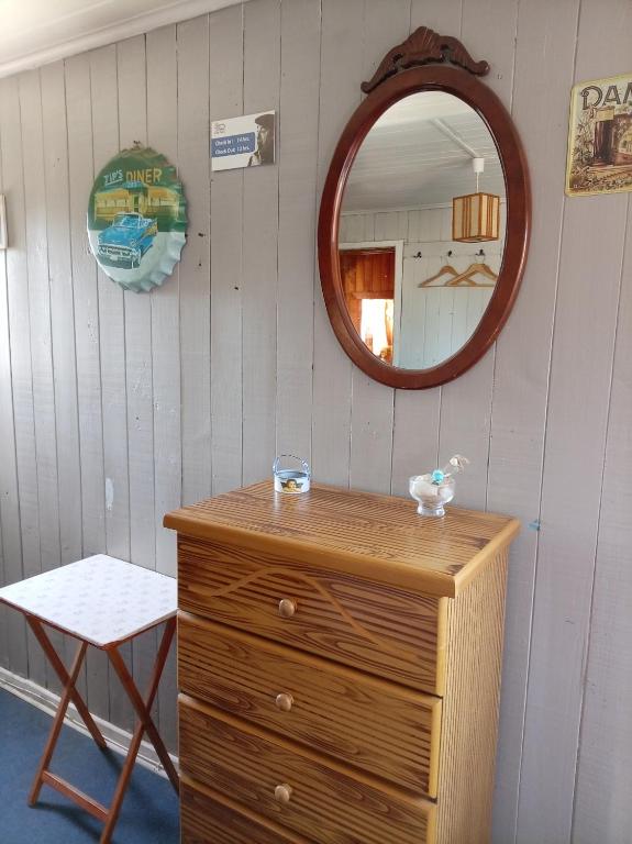 a mirror and a wooden dresser in a room at Habitación Bosque Mar in Isla Negra