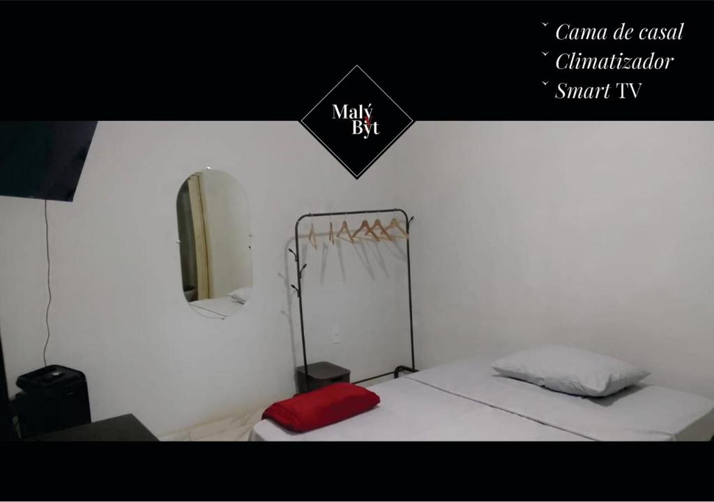a room with a bed and a sign that says walk exit at Malý Byt in São João Nepomuceno