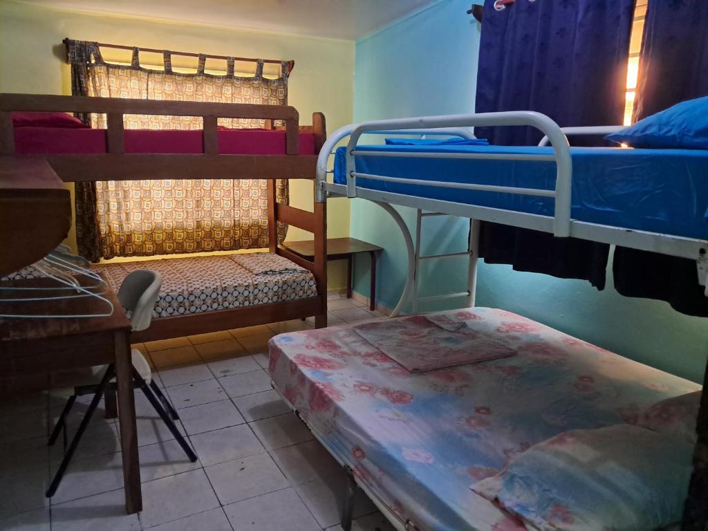 a room with two bunk beds and a table at Hostel Archimedes in Paramaribo