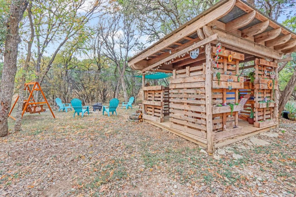a wooden play structure with chairs and a playground at Wild Rhodes in Wimberley