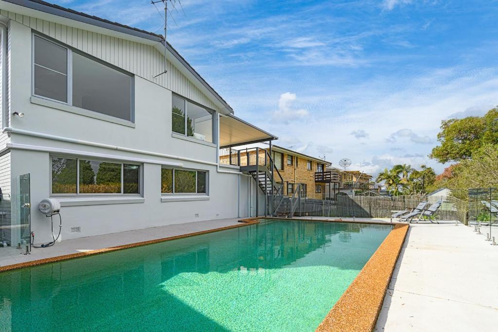 a swimming pool in front of a house at Collaroy 3Br Beach Home with Large Pool Ground Floor in Collaroy