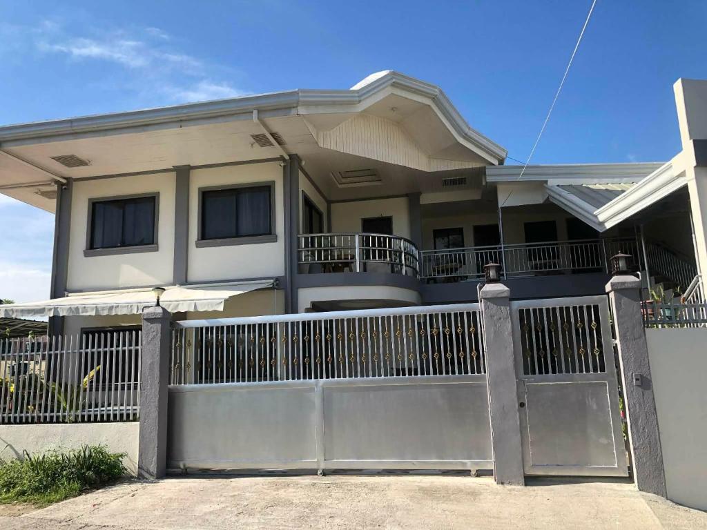 a house with a gate and a fence at D Estelita Guest House in Moalboal