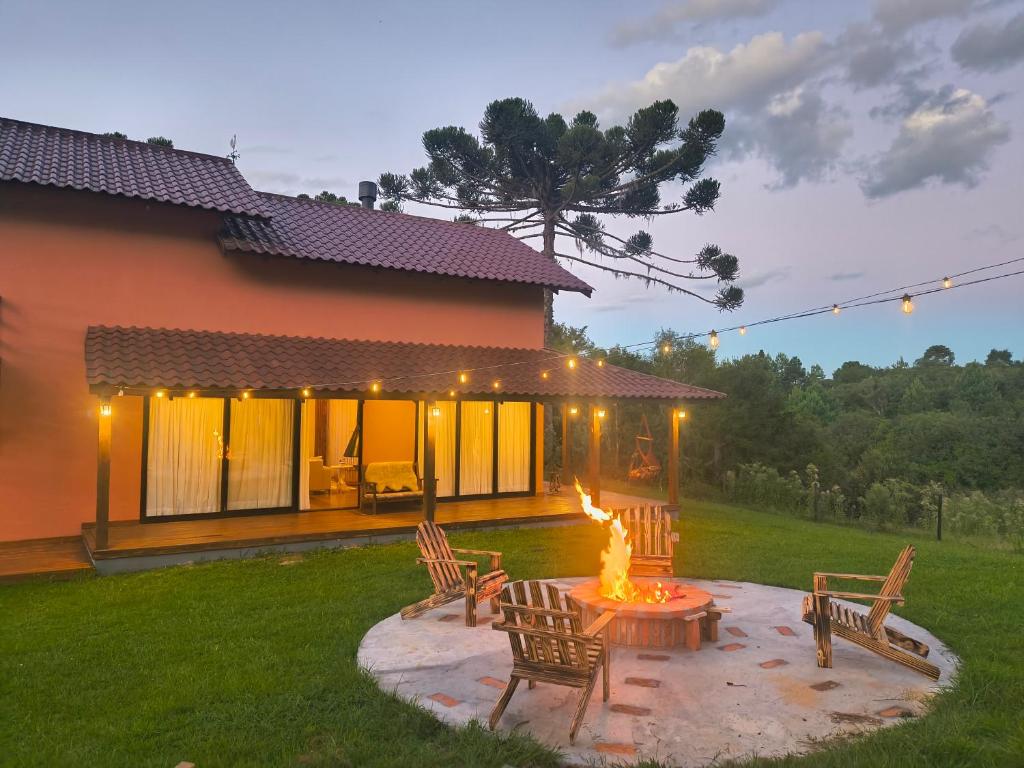 a fire pit in a yard next to a house at Casa de campo Aconchego Serrano in Lages
