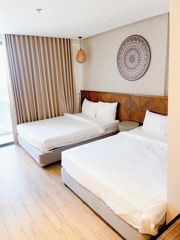 a hotel room with two beds and a window at Blue View Apec Tuy Hoa in Tuy Hoa