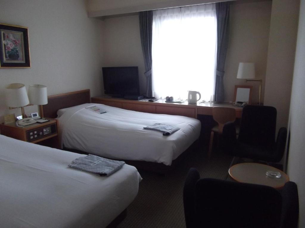 Postel nebo postele na pokoji v ubytování Ichikawa Grand Hotel