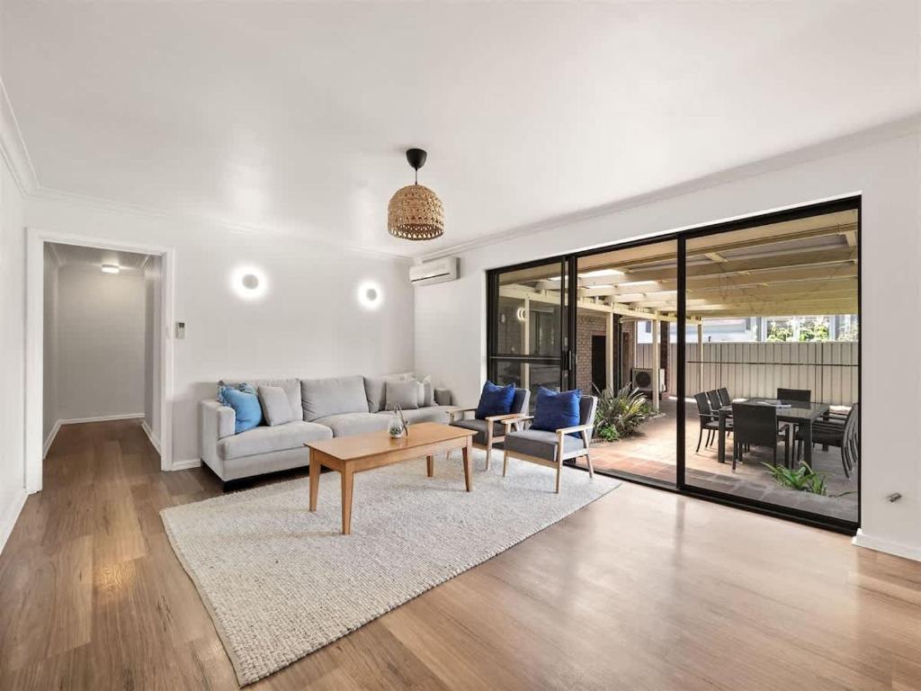 a living room with a couch and a table at Bluewater Retreat - Pet-Friendly Coastal Oasis in Broadwater