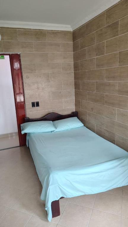 a bed in a room with a brick wall at Hotel Real Caracoli in Guamal