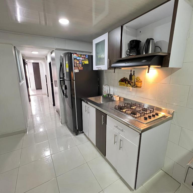 a kitchen with a stove and a refrigerator at Apartamento cerca mall plaza in Manizales