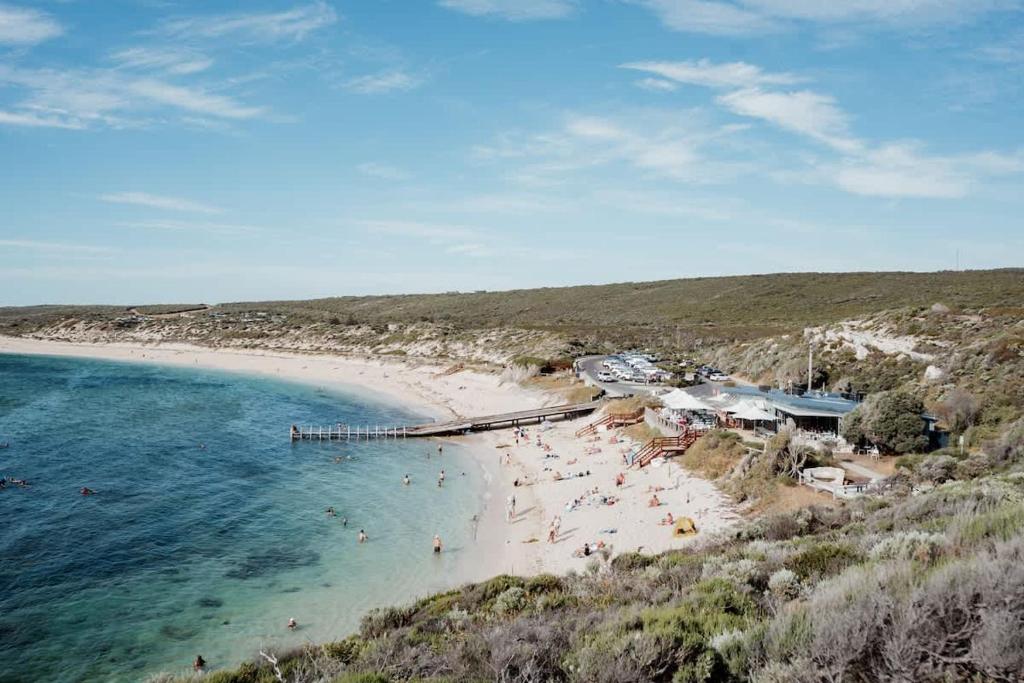 a beach with people on the sand and the water at Blue Haven Townhouse - Beachside Retreat with Pool Access in Gnarabup