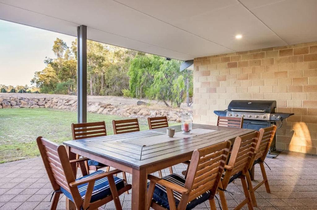 a dining room with a table and chairs and a grill at Cockatoo Lodge - Winery Retreat at Rivendell Estate in Yallingup Siding