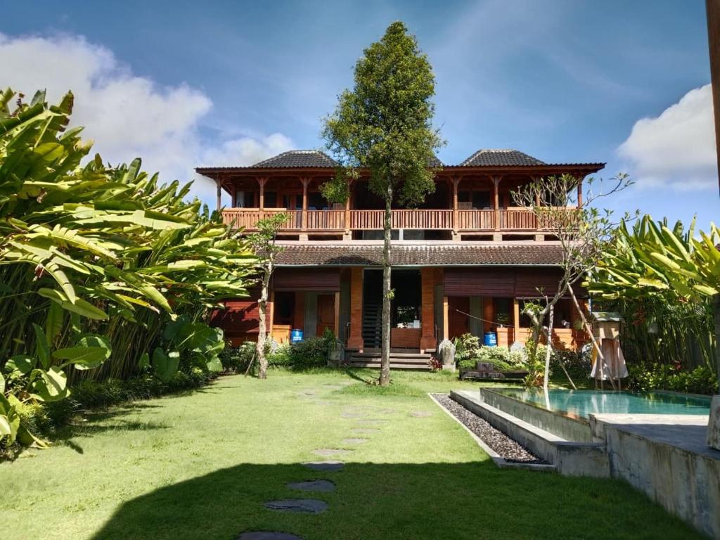 a house with a swimming pool in front of it at Rana Suite in Ubud