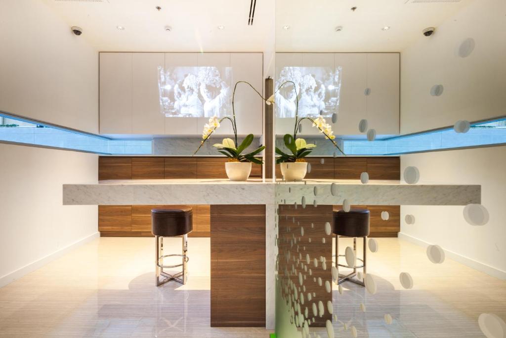 A compact kitchenette or work counter with two stools and mirrored finishes.