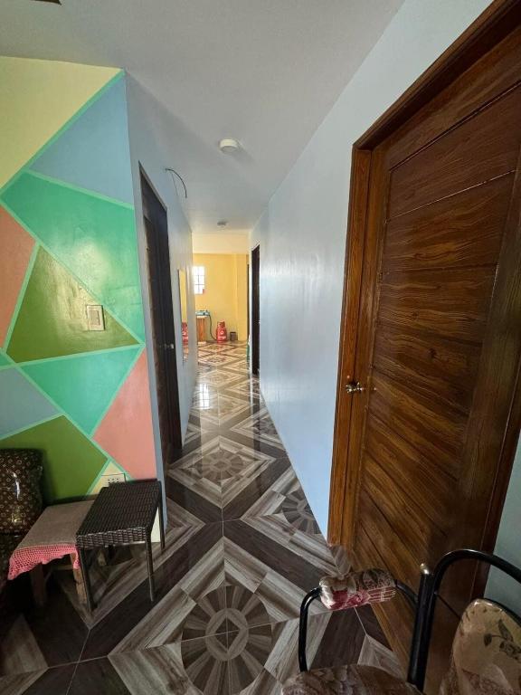 a hallway with a tile floor and a wooden door at Rjoyz transient house in Itogon