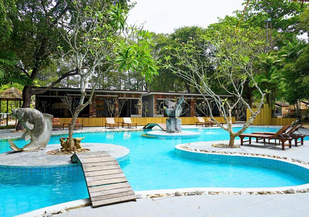 a swimming pool with two statues in a resort at Villa Cha Cha Chaolao Beach Resort in Chao Lao Beach