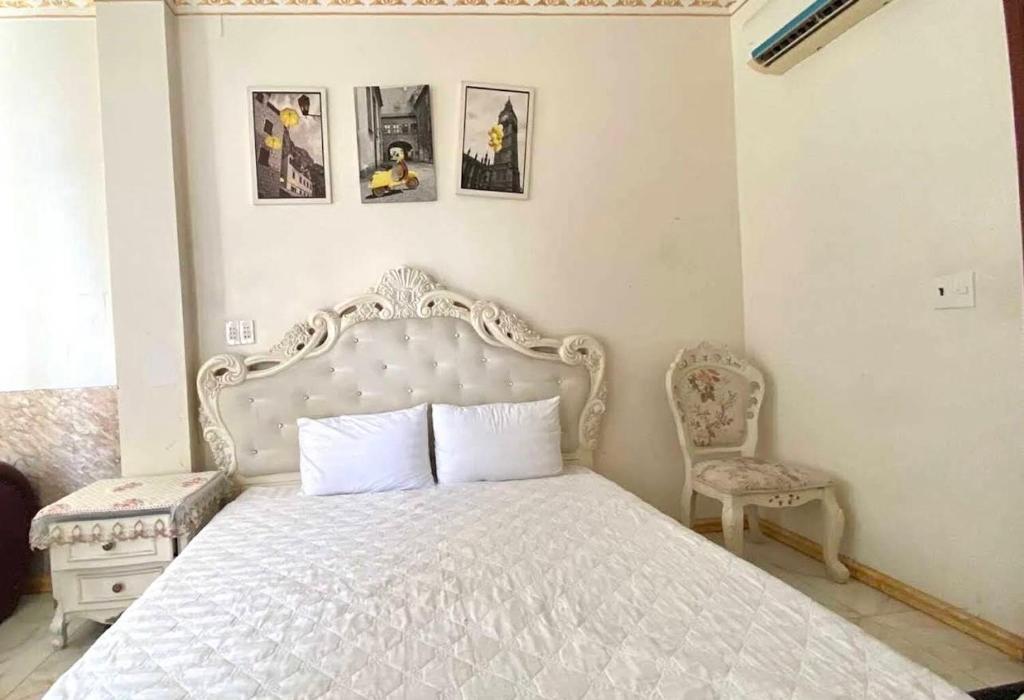 a bedroom with a white bed and a chair at King hotel in Dĩ An