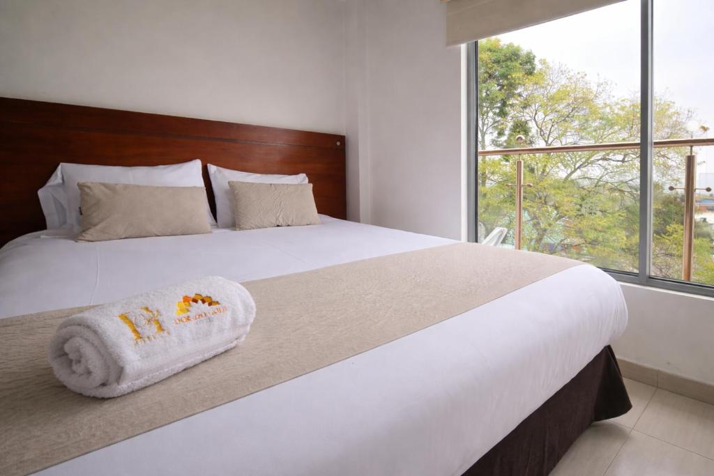 a bedroom with a large bed with a towel on it at Hotel Dorado Gold in Bogotá