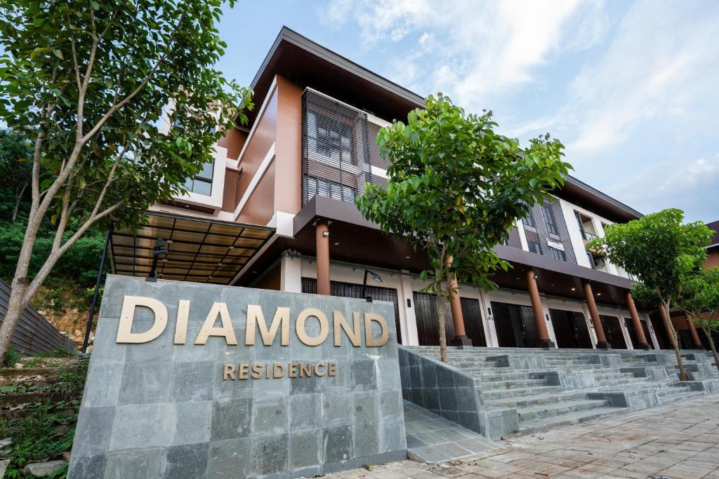 a sign in front of a building with a diamond residence at Green Hill Service Apartment in Labuan Bajo